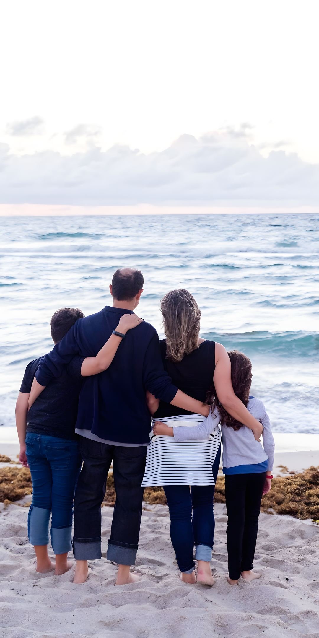 A family hugging at the beach